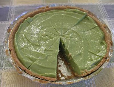 Avocado Pie with one slice missing in a glass pie dish