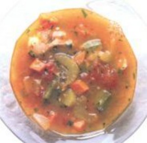 An overhead photo of Bermuda Fish Chowder chunks of peppers, tomatoes and fish in a bowl