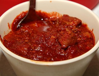 Tolbert's Bowl of Red Chili in a white bowl with a spoon