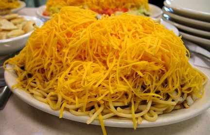 Bowl of Cincinnati Chili topped with mounds of shredded cheese.