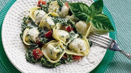Creamy Spinach and Tortellini served on a large white dinner plate