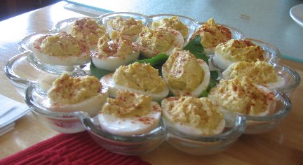 deviled eggs arranged in a glass egg serving dish