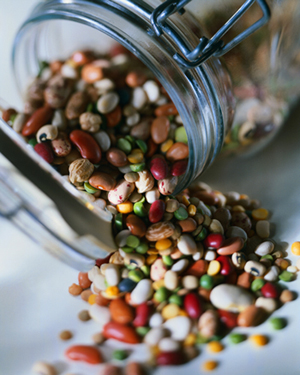 mixed dried beans spilling out of a glass jar