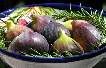 figs in a white bowl with fall branches as garnish