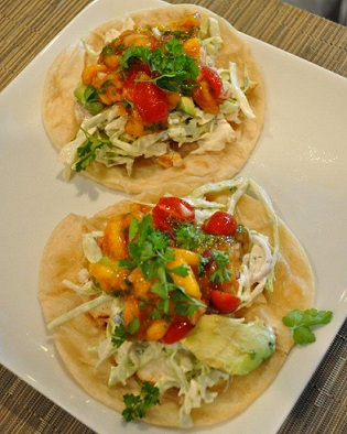 two fish tacos served on a white square plate