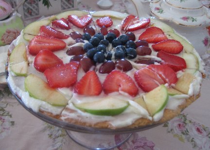 Fruit Dessert Pizza with grapes on a glass cake stand