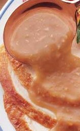 close up image of gravy being spooned over a dish
