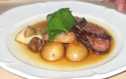 Spicy Flank Steak plated with potatoes and garnish on a white plate