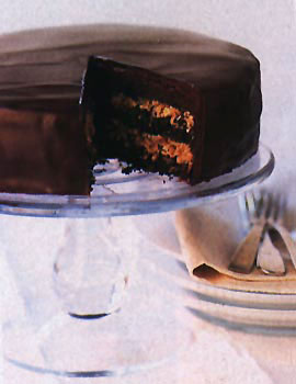 Inside Out Chocolate Cake on a glass cake platter with one slice cut out