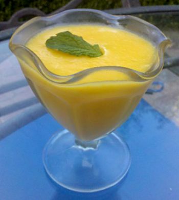 Mango Custard from served in a ruffled edge glass on a blue table