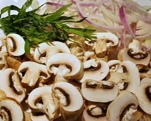 fresh sliced mushrooms and onions on a cutting board