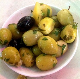 marinated green olives in a small white bowl