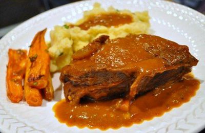 pot roast with vegetable sides served on a white decorative plate