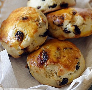 close up of raisin scones in a basket lined with white napkins from the scone recipes collection