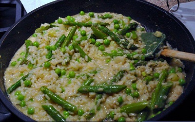Lemon Risotto with green beans cooking in a black skillet