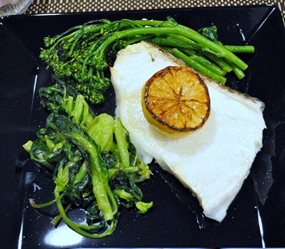 Sea Brass with broccoli from the whitefish recipe collection plated artfully on a black dish