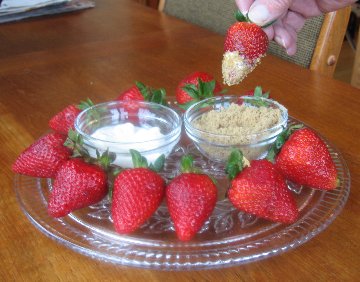 Simply Strawberries on a glass platter with two small bowls of toppings