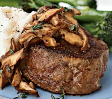 Serving of Beef Tenderloin Steak Stuffed with Morel Mushrooms and cooked in mushroom wine sauce  on blue plate