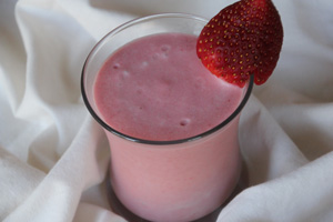 tropical smoothie with strawberry garnish