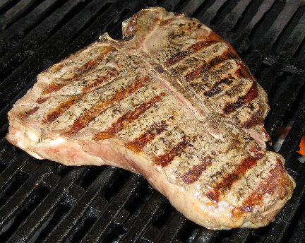 T-bone steak cooking on a grill 