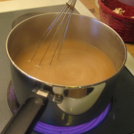 whisking Turkey Gravy as it cooks on a stove