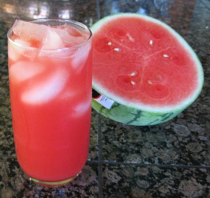 Watermelon Aqua Fresca in a all glass next to a cross section of watermelon
