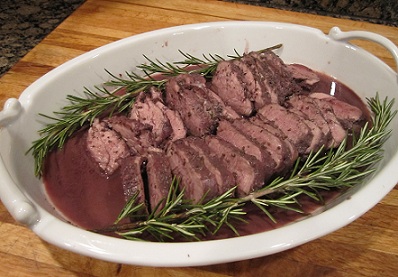 Zinful Pork Tenderloin in a white baking dish garnished with rosemary