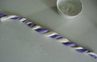 purple and white fondant snakes twisted together next to a bowl
