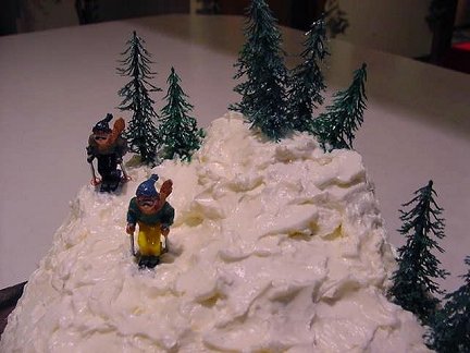 Ski Slope Cake with pine trees and two skiers 