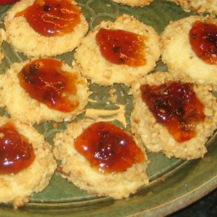 Plate of savory Cheddar Cheese Thumbprint Cookies topped with pepper jelly 
