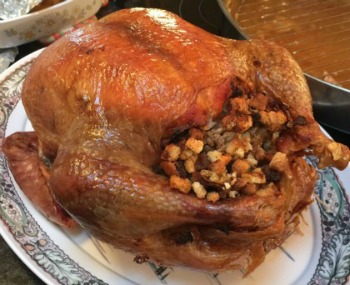 fully cooked turkey with stuffing on a serving dish