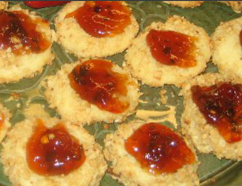 Plate of savory Cheddar Cheese Thumbprint Cookies topped with pepper jelly