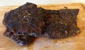 fully cooked beef brisket on a wooden cutting board