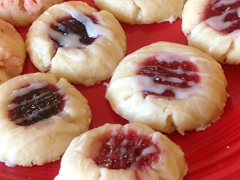 Baked thumbprint cookies filled with blackberry and raspberry jam and drizzled with vanilla icing.