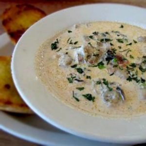 Oyster Stew in a bowl with slices of homemade bread on the side