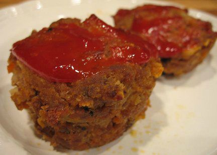 two Meat Loaf Muffins dressed with ketchup on a white plate