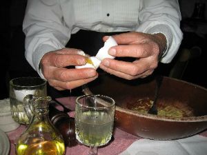 hands of a chef cracking an egg into a glass preparing to coddle