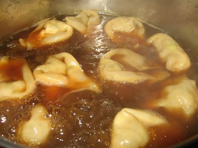 wontons boiling in chicken stock