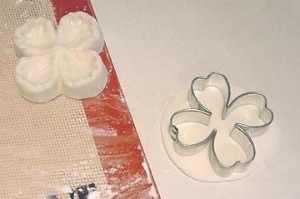 cookie cutting gum paste into small white flowers