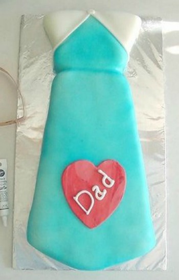 Fathers Day Cake in the shape of a tie with a red heart and the word dad written in white icing