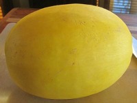 whole spaghetti squash sitting on a cutting board