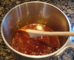 Caramel Sauce cooling off and being stirred by wooden spoon