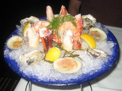 shrimp and oysters on ice in blue bowl for seafood recipes