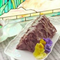 Triangle Cake a white dish garnished with edible flowers | baking corner