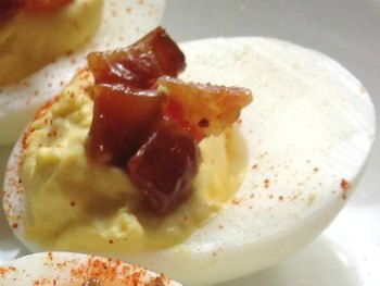 close up image of deviled egg with candied bacon
