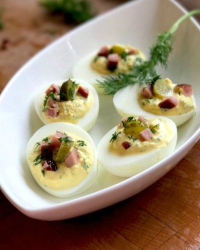 Dill Pickle Deviled Eggs served in a white boat shaped dish
