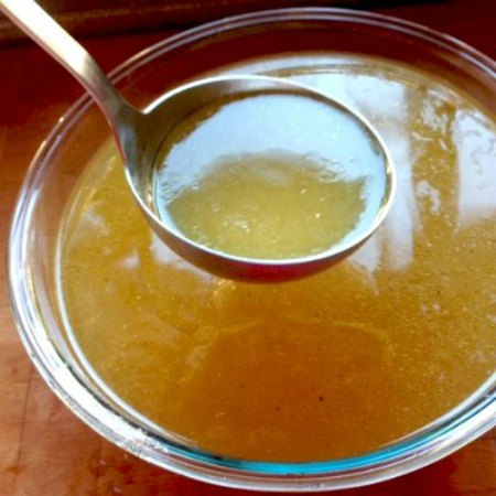 Chicken Bone Broth ladled out of a glass bowl